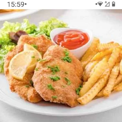 Recipe of breaded chicken with french fries and lots of lettuce and parsley and the red sauce on the DeliRec recipe website
