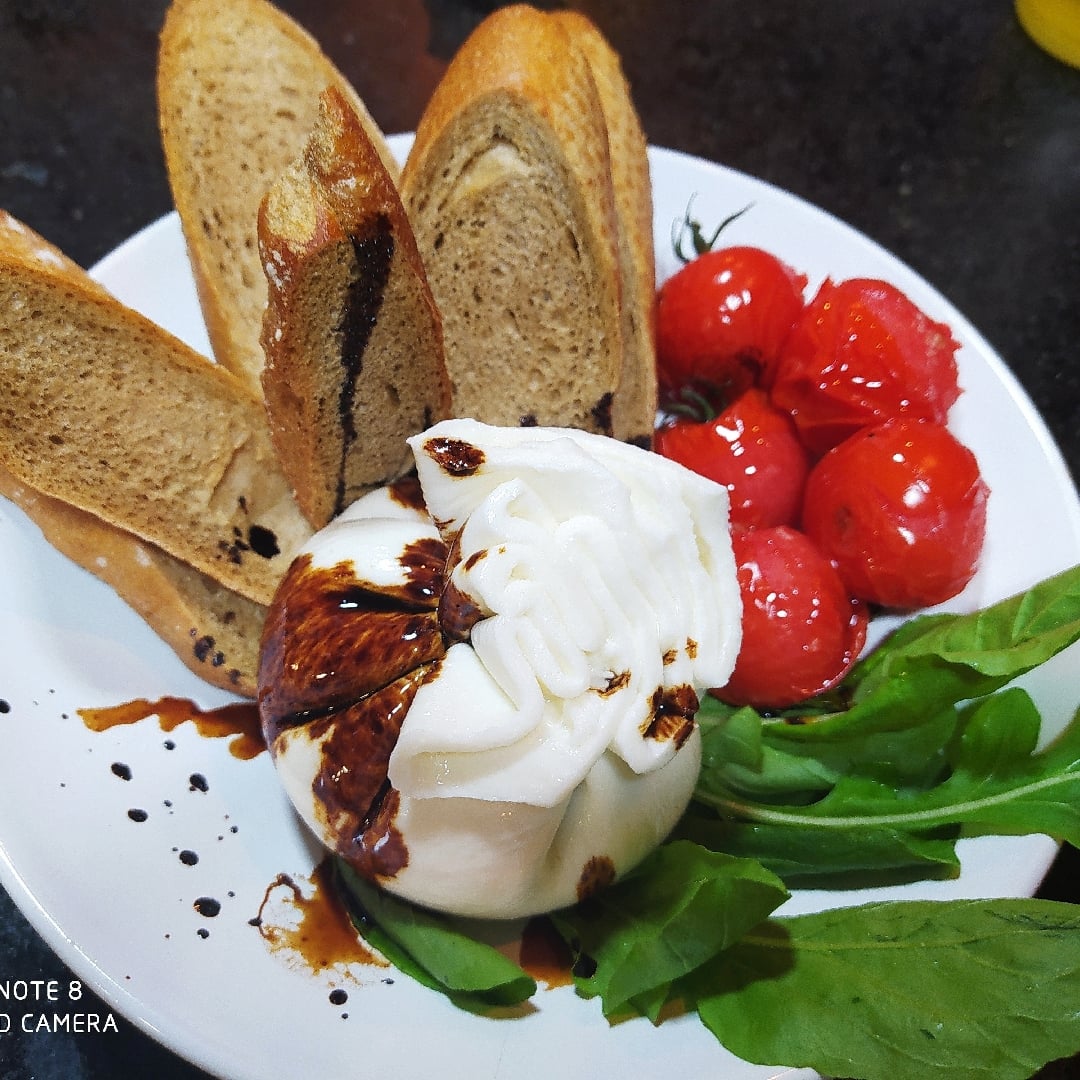Photo of the Burrata on a bed of Italian bread, candied cherry tomatoes and arugula in a balsamic reduction. A great entry to share – recipe of Burrata on a bed of Italian bread, candied cherry tomatoes and arugula in a balsamic reduction. A great entry to share on DeliRec